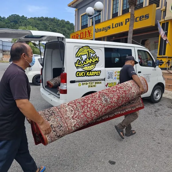Pekerja mengangkat karpet rumah yang digulung ke dalam van Kluang Cuci Karpet